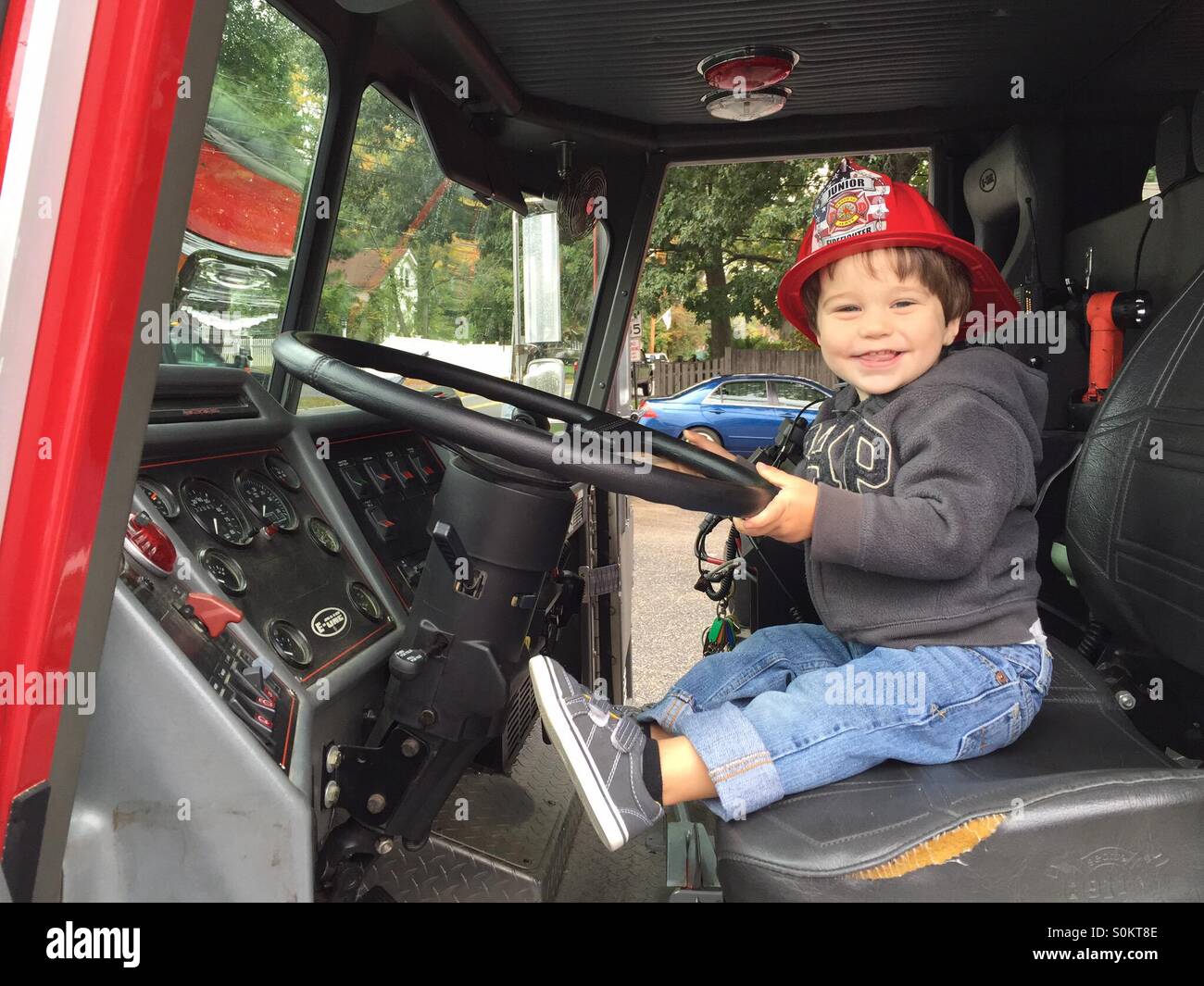 Two year old boy sits in a ladder truck at the open house, Wayland Fire Department in Wayland, Massachusetts. - Smartphone Captured Stock Image