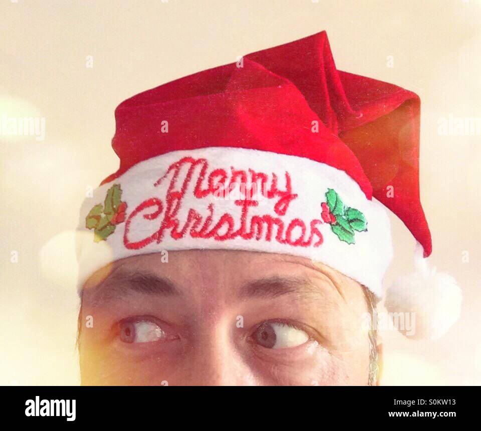 Partial portrait of a man looking right way, with a Christmas hat Text: Merry Christmas - Smartphone Captured Stock Image