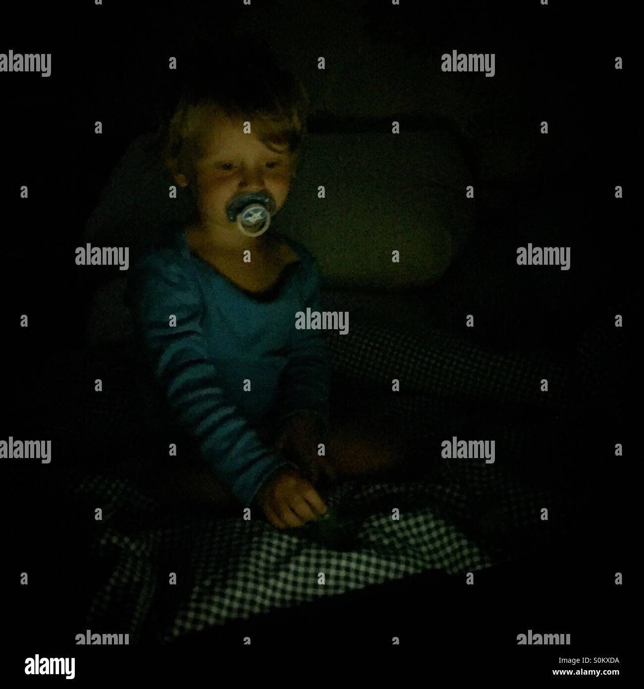 Toddler playing with tablet computer in bed - Smartphone Captured Stock Image