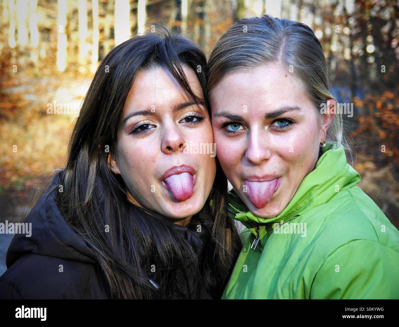 Two girls sticking tongue out Stock Photo