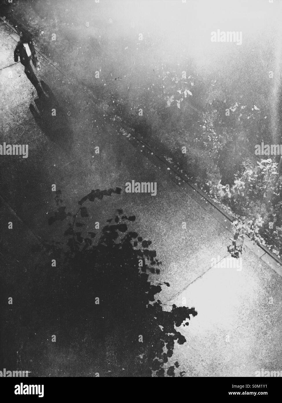 Rainy night. Man walking under street lights. - Smartphone Captured Stock Image