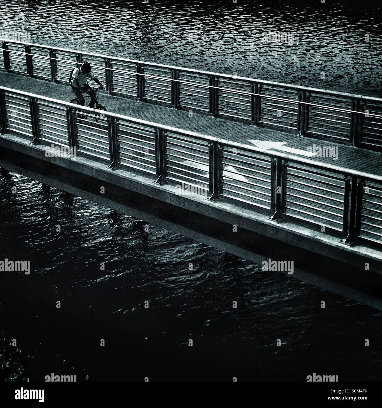Man biking on the Schuylkill River Boardwalk , Philadelphia, Pennsylvania - Smartphone Captured Stock Image