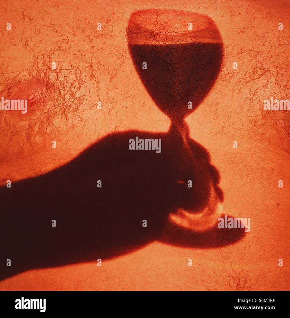 Shadow in mans chest of hand holding glass of wine - Smartphone Captured Stock Image