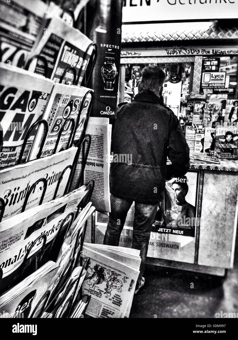 Man at a newspaper stand on the underground in Berlin Stock Photo