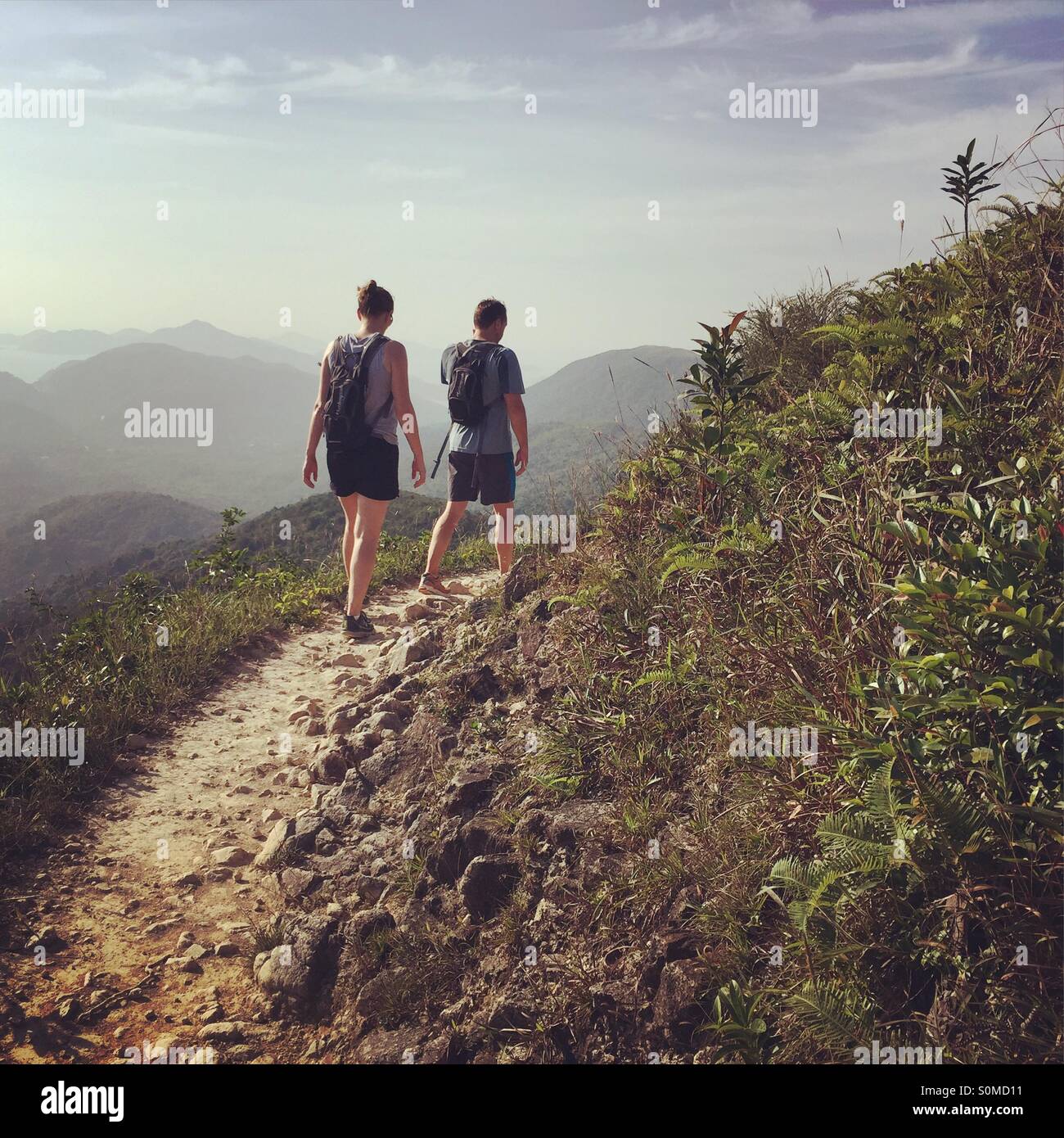 A man and a woman walking in the hills Stock Photo