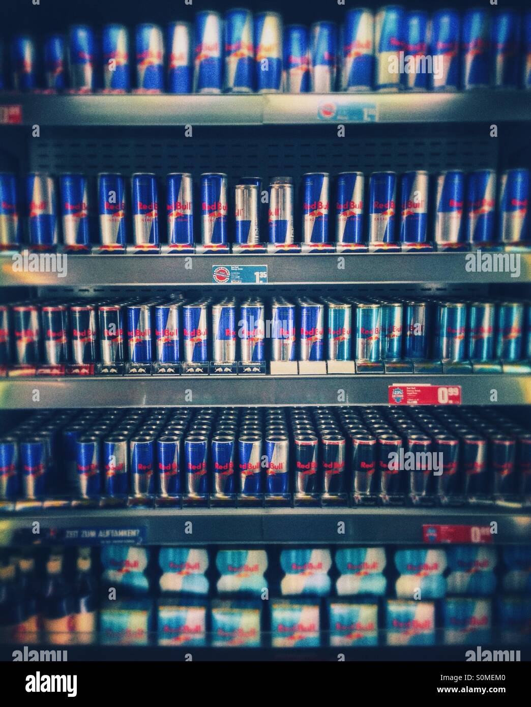 A display of Red Bull cans in a cooling shelf in a supermarket Stock Photo
