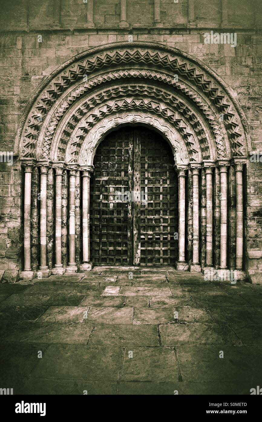 A darkened, textured church doorway provides an ornate entrance. - Smartphone Captured Stock Image