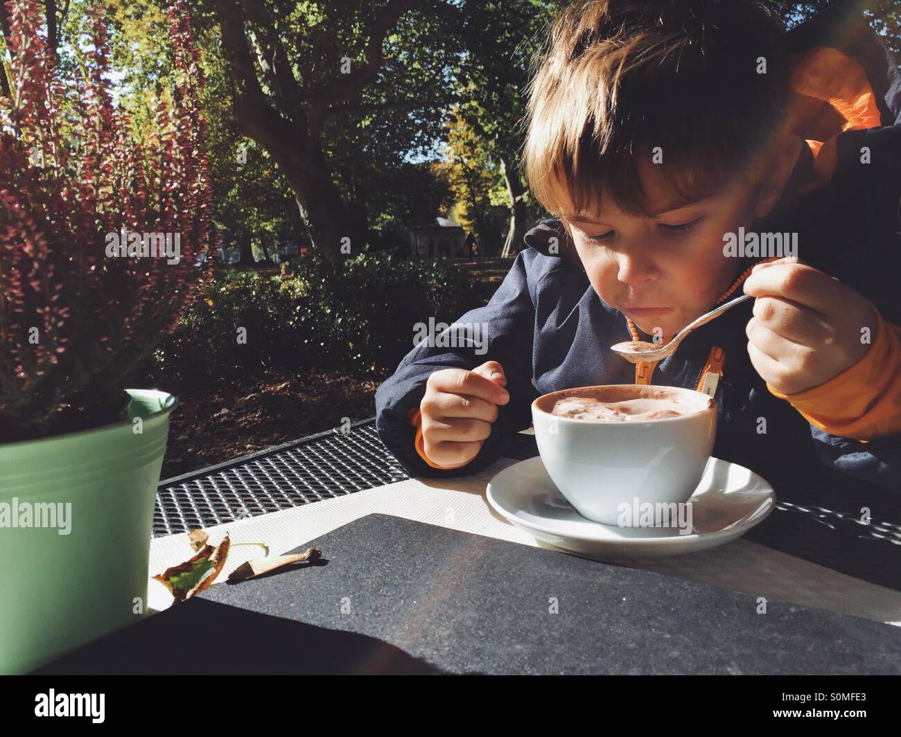 Five year old boy drinking hot chocolate outside Stock Photo