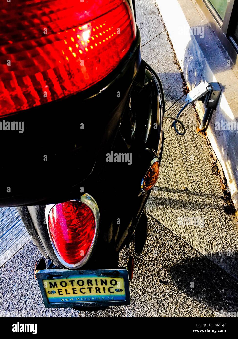 Electric motorcycle plugged in - Smartphone Captured Stock Image