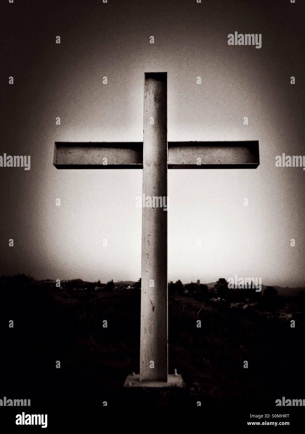 A steel cross on top of a mountain stands against the sky, black-and-white - Smartphone Captured Stock Image