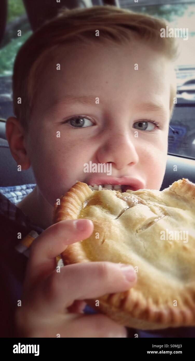 Young boy eating a pie Stock Photo Alamy
