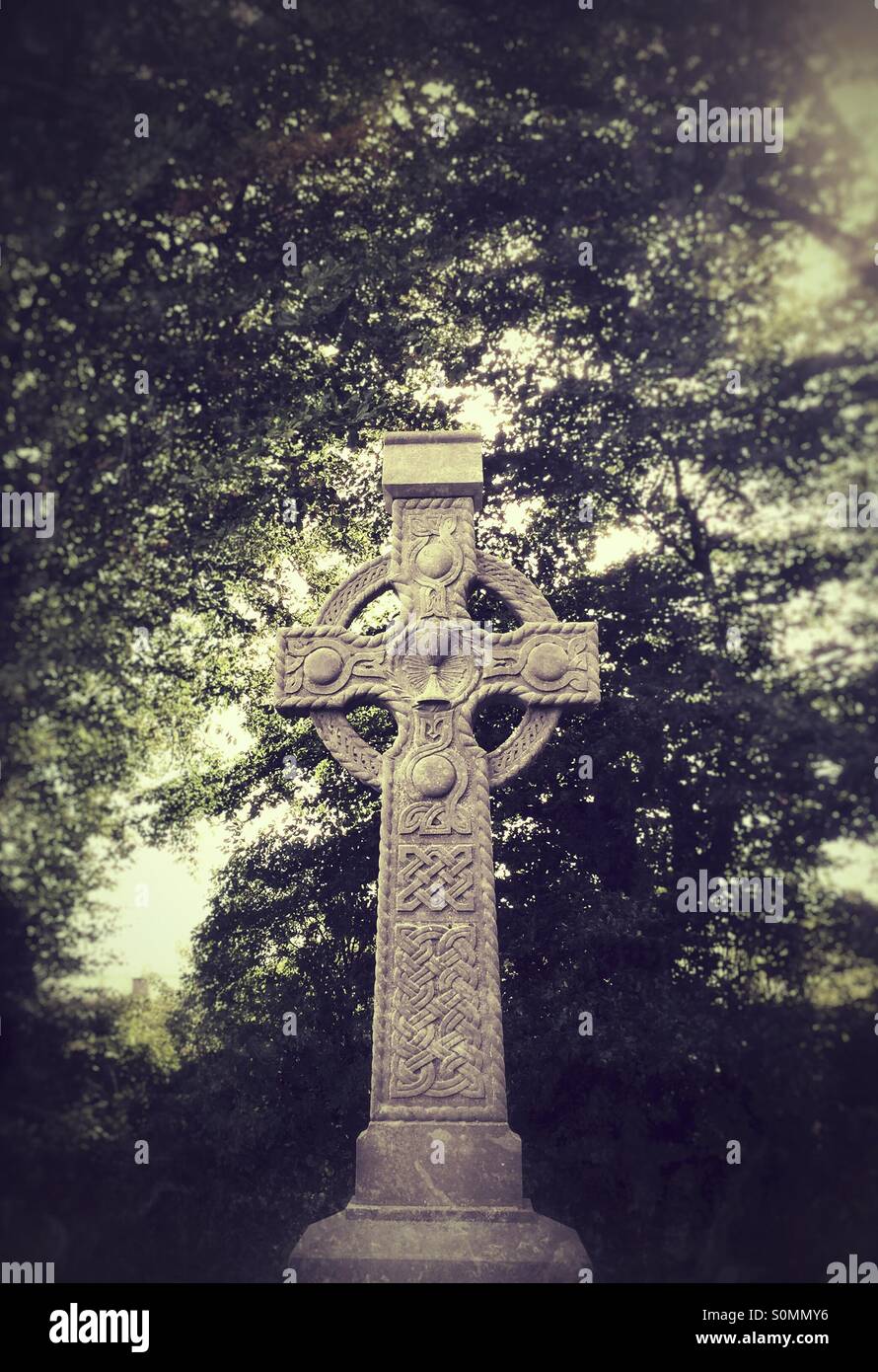 Celtic cross gravestone in church cemetery in Ireland - Smartphone Captured Stock Image