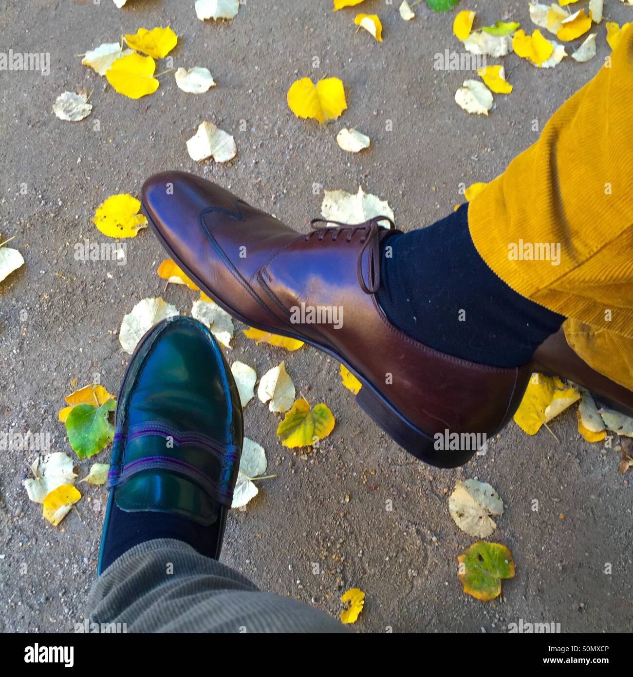 Shoes of two men with colored leaves in Autumn, Paris, France - Smartphone Captured Stock Image