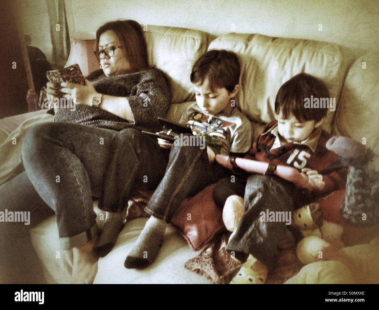 Family using gadgets on the sofa. - Smartphone Captured Stock Image