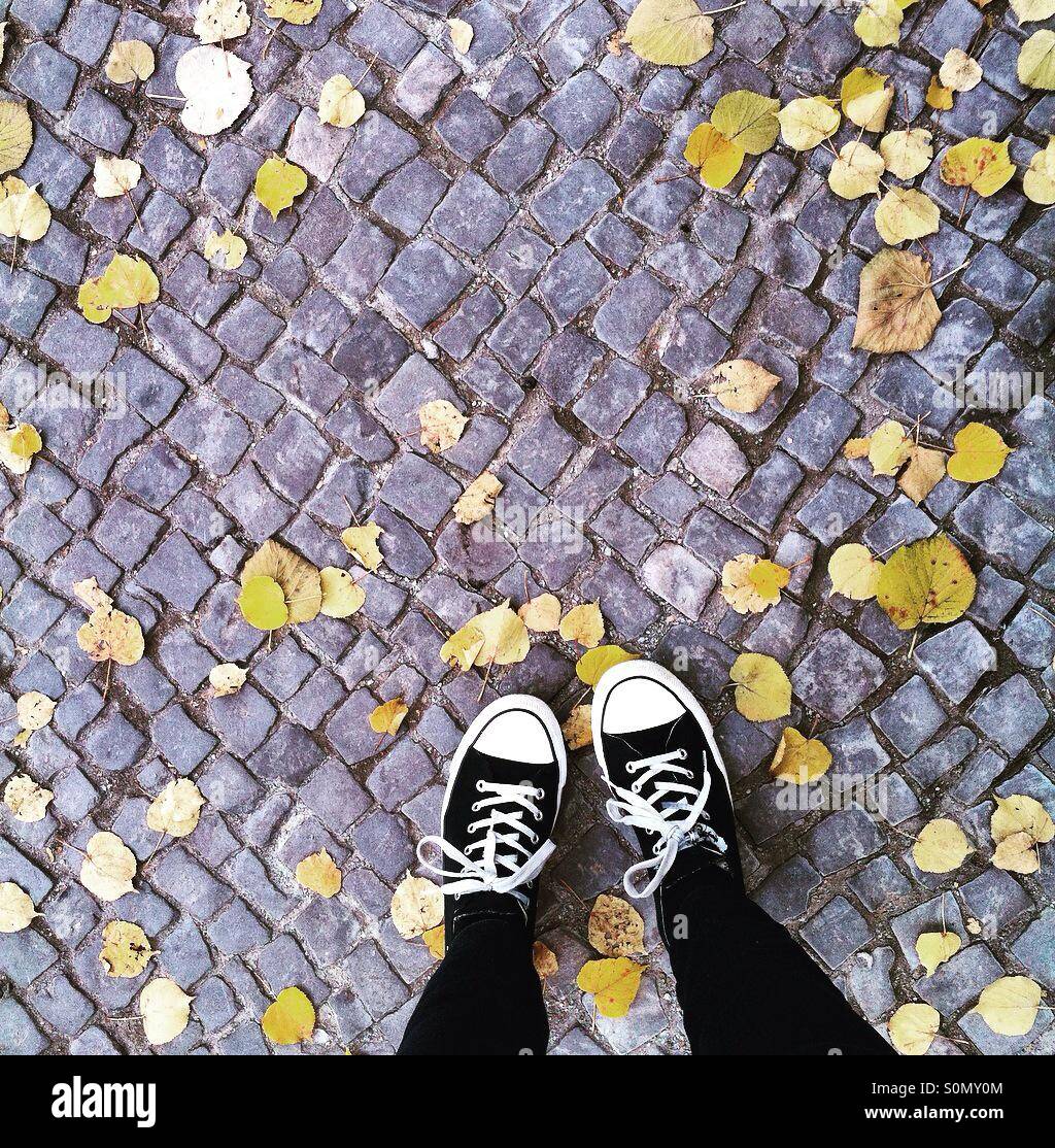 Looking down at feet on a Berlin pavement in autumn - Smartphone Captured Stock Image