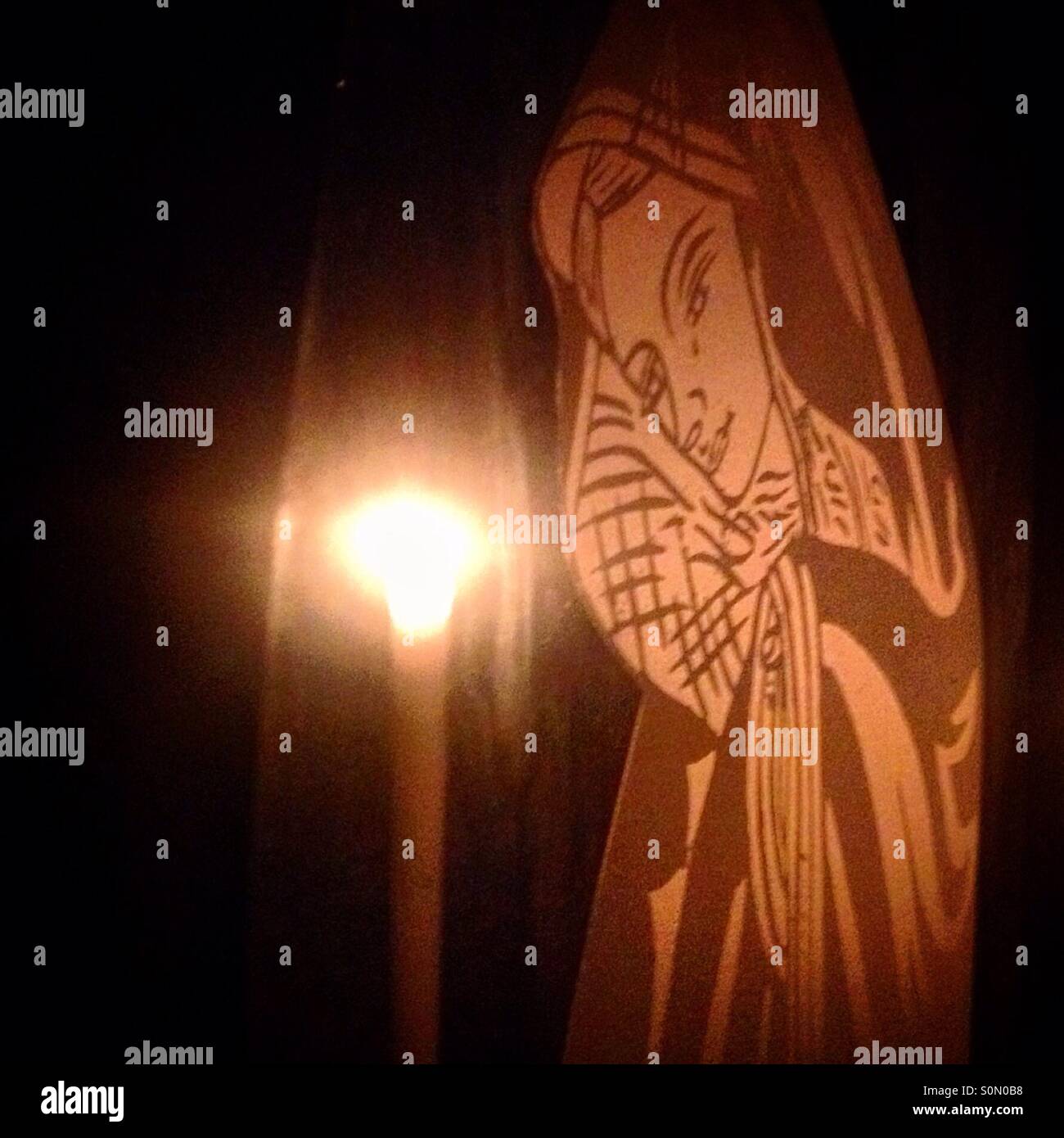 An image of the Virgin Mary and a candle in San Gregorio Atlapulco,Mexico City.Day of the Dead celebration mixes Pre-Hispanic traditions with the European tradition of the Catholic All Souls Day. - Smartphone Captured Stock Image