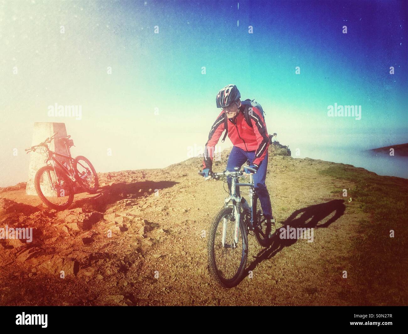 Cyclist on mountain bike on top of Worcestershire Beacon Malvern hills Worcestershire uk. November 2015 - Smartphone Captured Stock Image