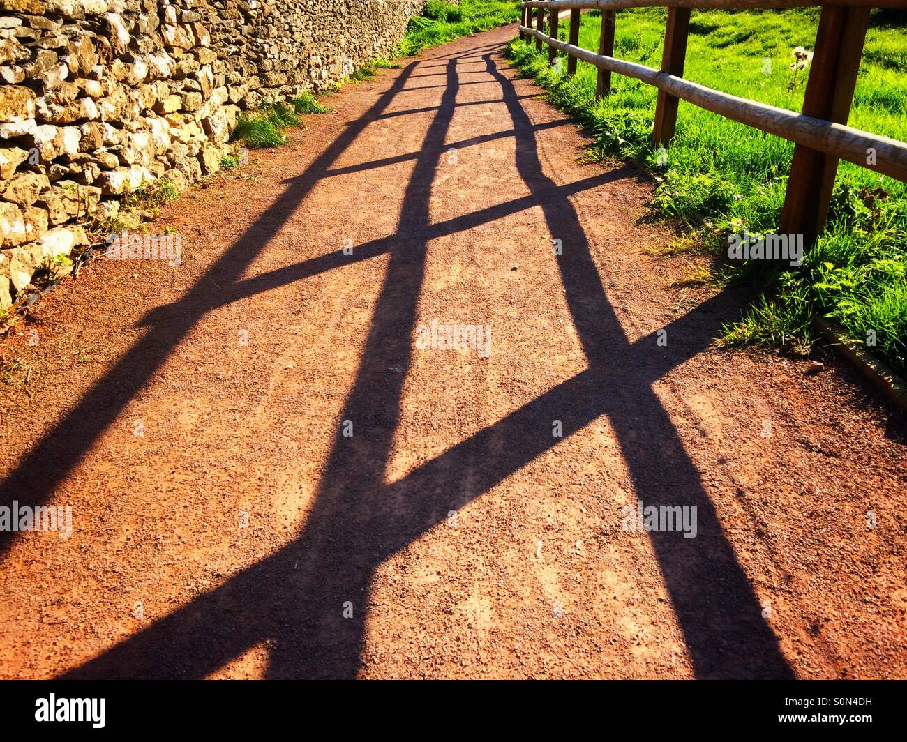Shadows of a fence on a path in the autumn sunshine - Smartphone Captured Stock Image