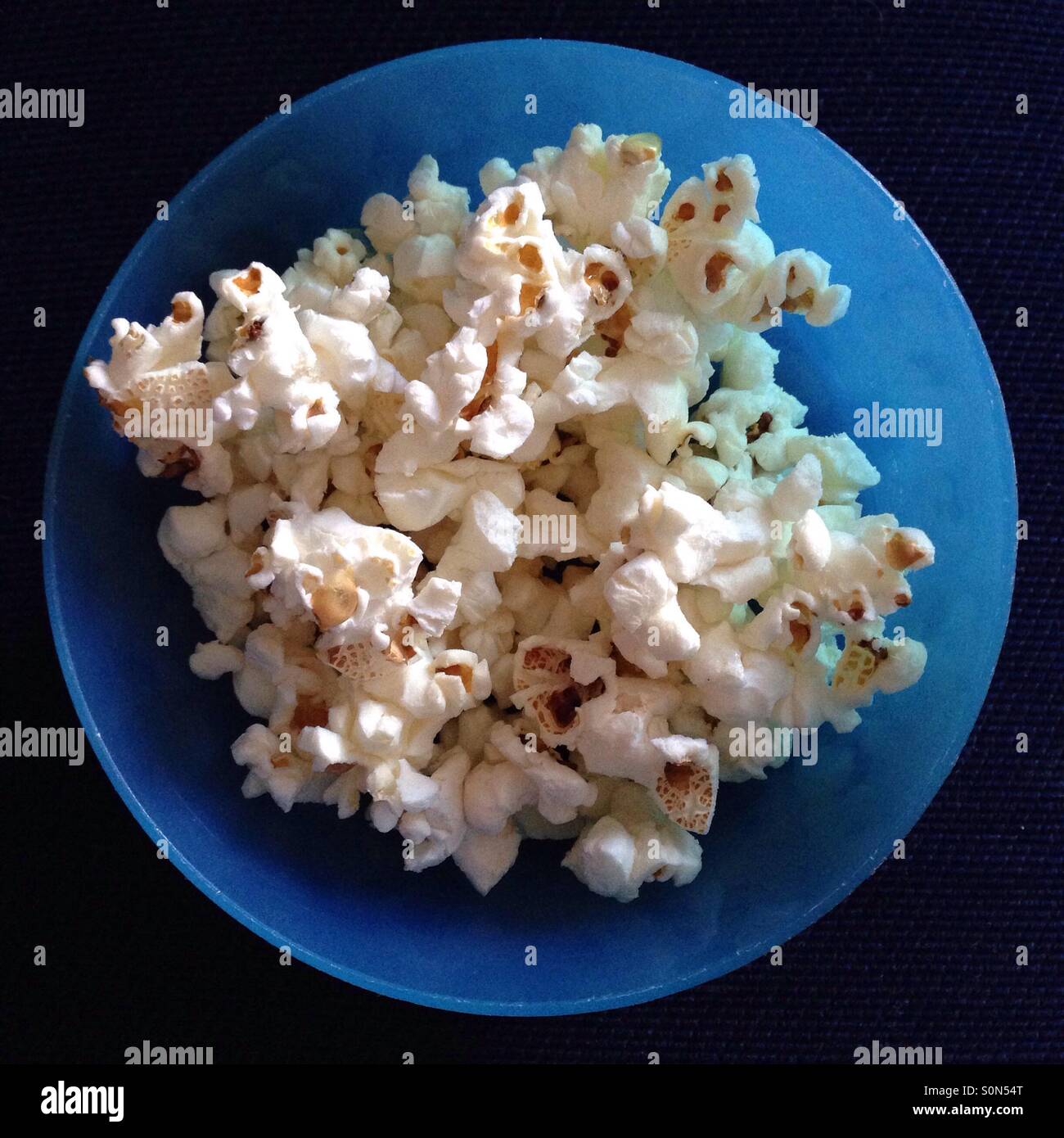 Popcorn in blue toddler bowl Stock Photo