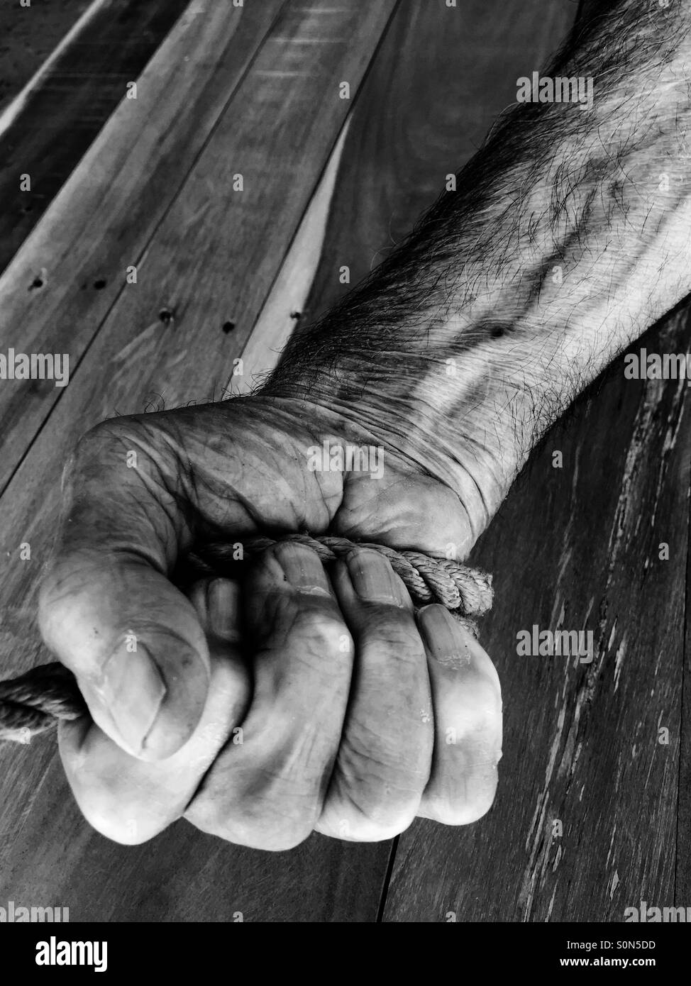 Old man pulling rope Stock Photo