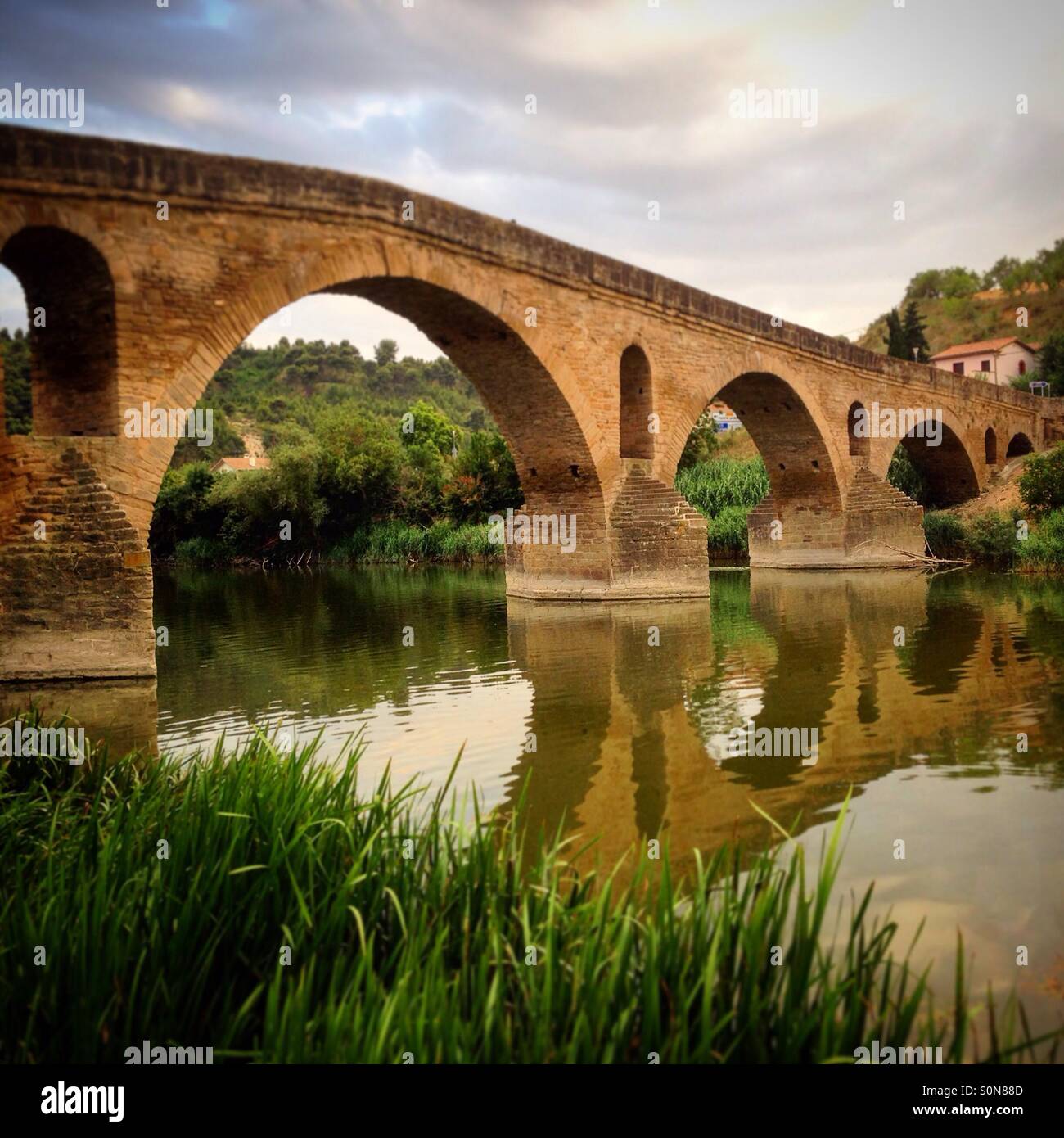 Old Bridge in a natural river. Puente de la Reina, Navarra, Spain - Smartphone Captured Stock Image