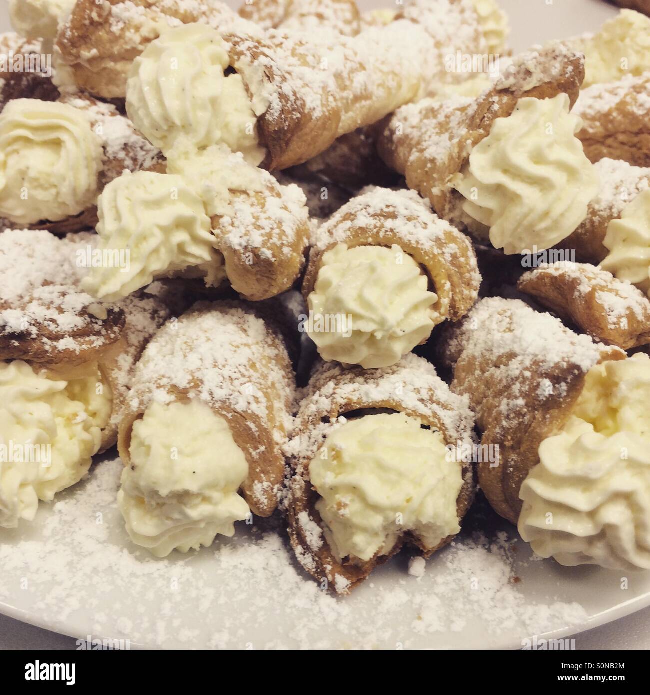 Italian cream horns for dessert. Made with chantilly cream cheese covered in powdered sugar or icing sugar. - Smartphone Captured Stock Image