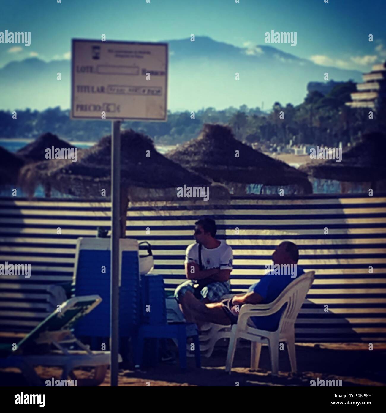 Sun bed attendants take a rest during the hottest November on record, Marbella Beach, Spain, 2015 - Smartphone Captured Stock Image