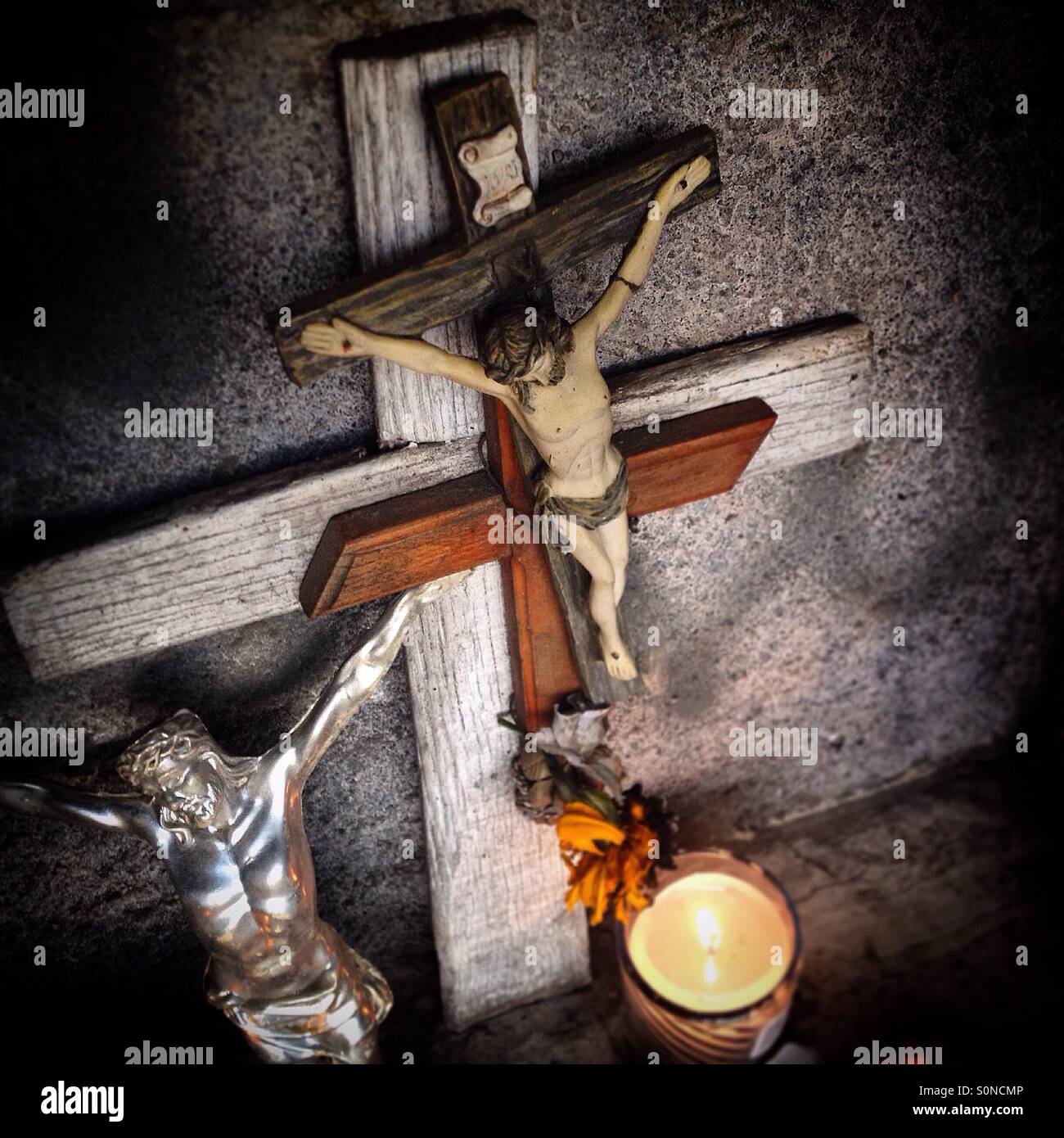 Crosses and a candle decorate a tomb during Day of the Dead celebrations in San Gregorio Atlapulco, Xochimilco, Mexico City, Mexico - Smartphone Captured Stock Image