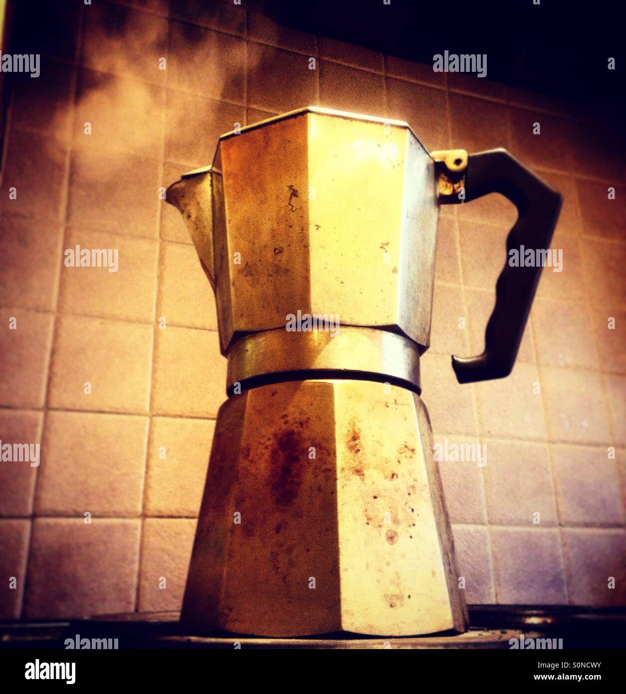 Espresso coffee pot steaming on a cooker Stock Photo Alamy