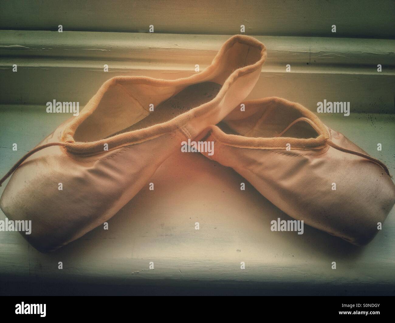 A pair of people no ballet shoes on a window sill. - Smartphone Captured Stock Image