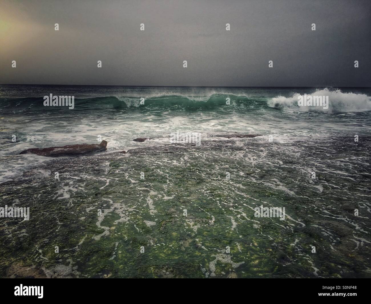 First break of waves over rocks - Smartphone Captured Stock Image
