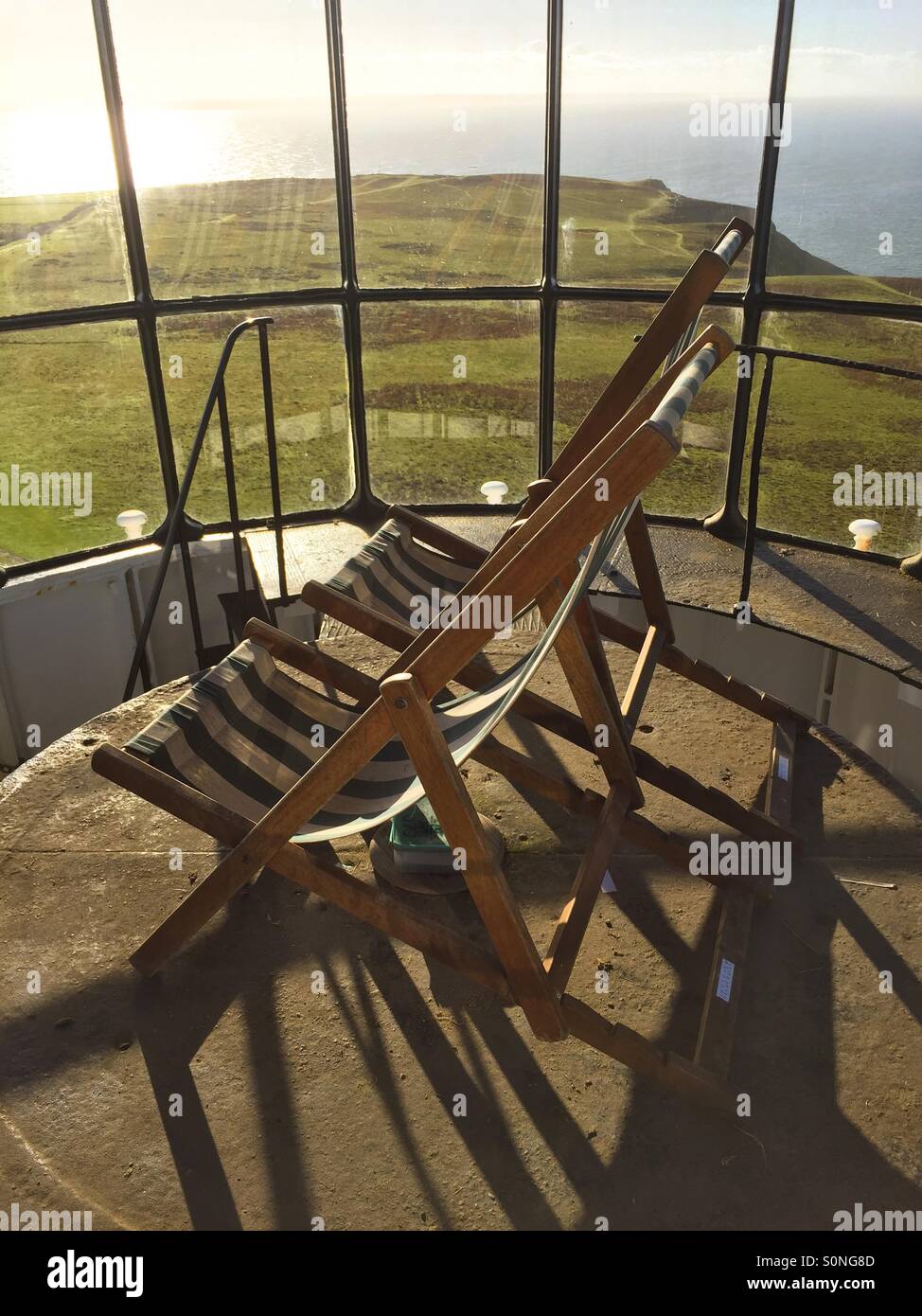 Looking out to sea, deckchairs at the top of an old Lighthouse - Smartphone Captured Stock Image