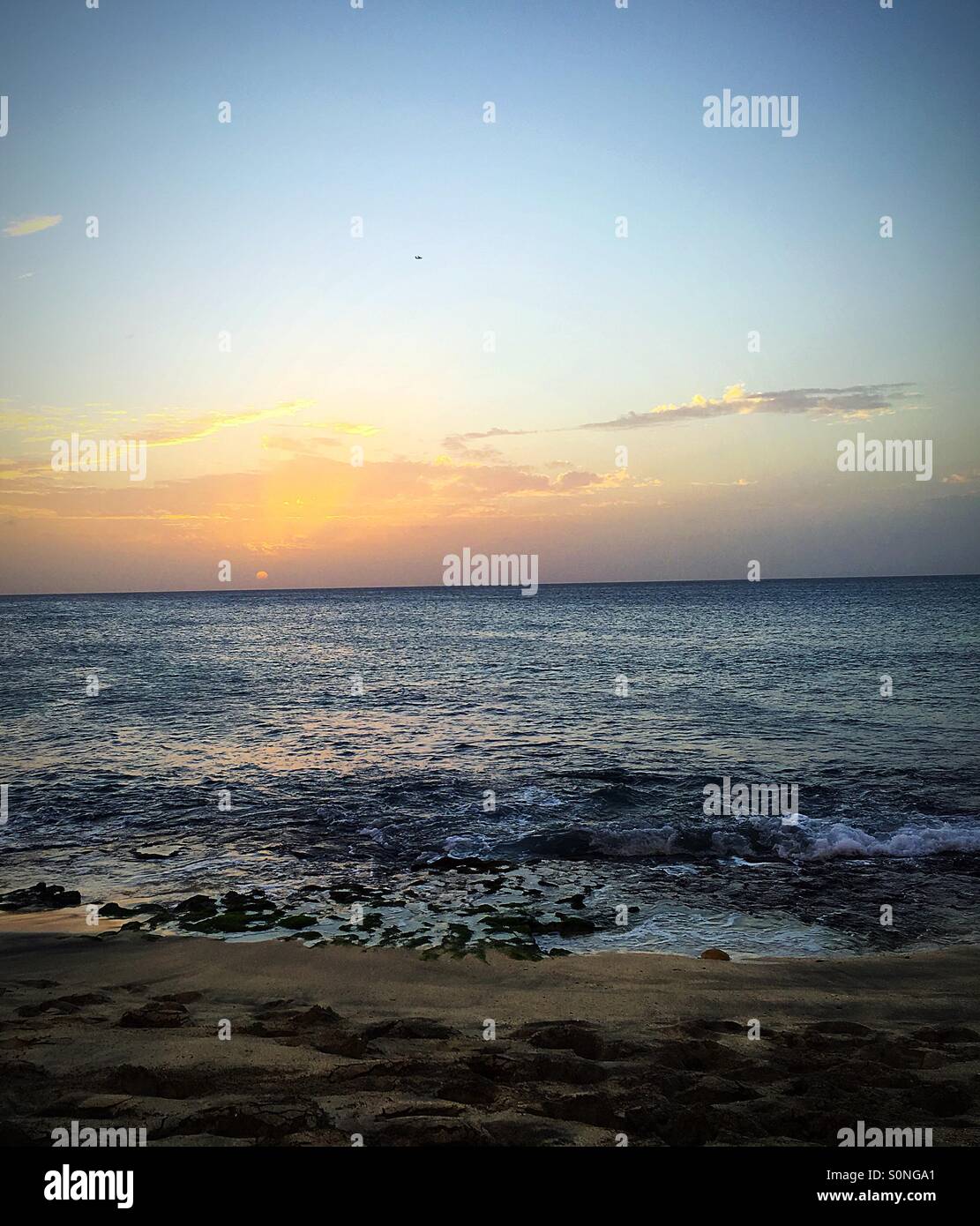 Full sun just before sunset over still ocean - Smartphone Captured Stock Image