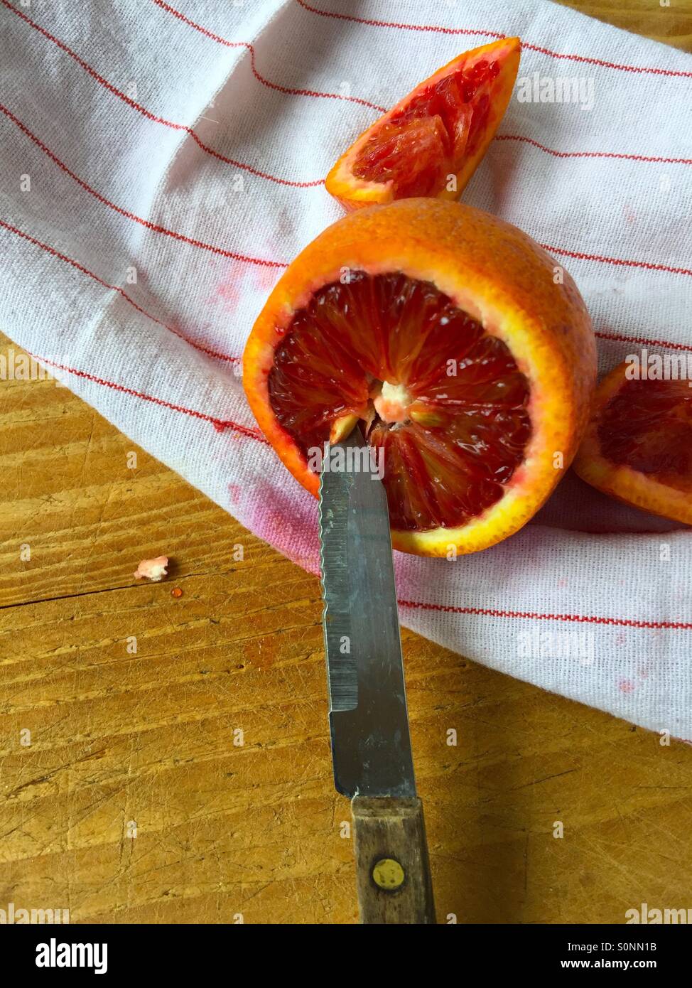 Removing seed from blood orange Stock Photo Alamy