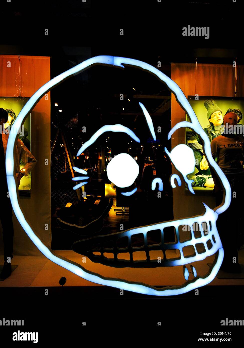 Illuminated neon skull in a shop window - Smartphone Captured Stock Image