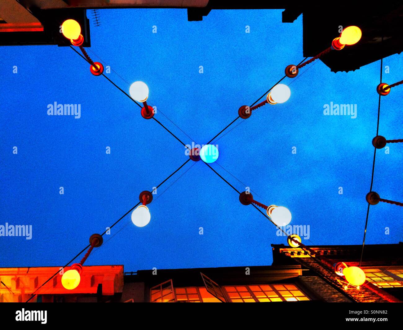 Red, white & blue Christmas lights over a street in London UK - Smartphone Captured Stock Image