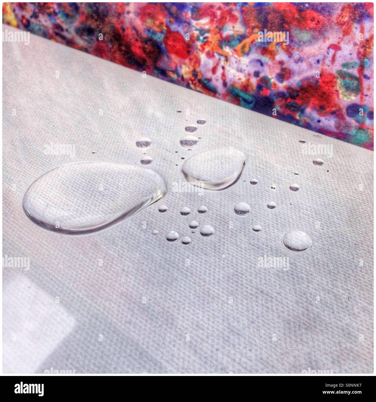 Water droplets on a white canvas - Smartphone Captured Stock Image