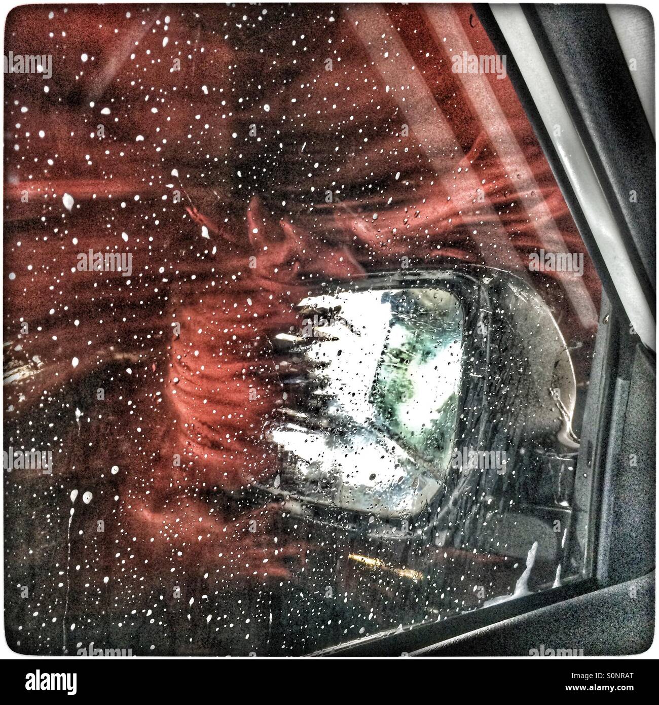 Roller cleaning side mirror in carwash. - Smartphone Captured Stock Image