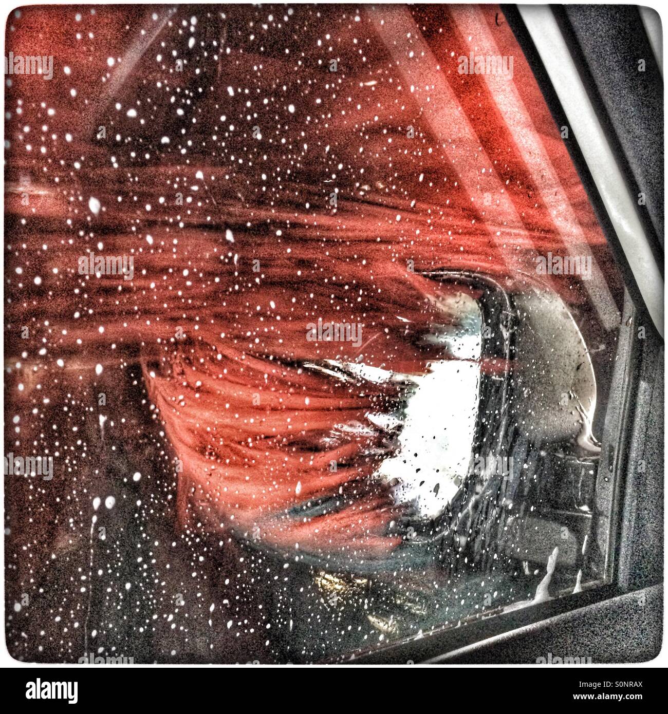 Roller washing side mirror in automatic carwash. - Smartphone Captured Stock Image