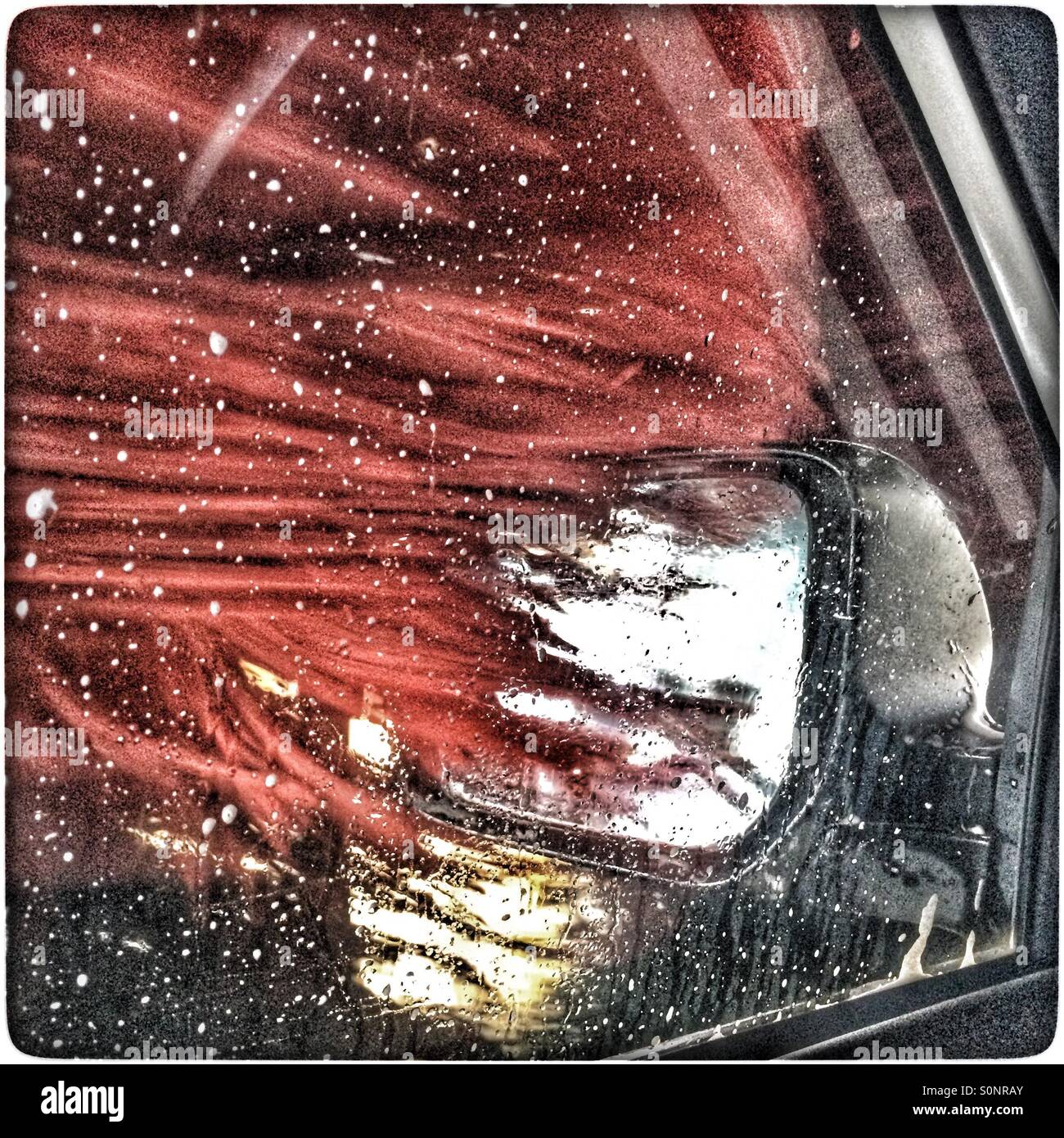 Roller cleaning side mirror in carwash. - Smartphone Captured Stock Image