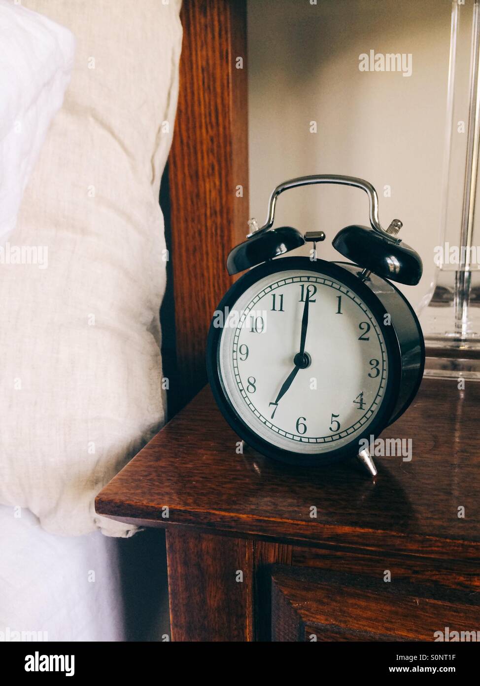 Alarm clock next to bed Stock Photo Alamy
