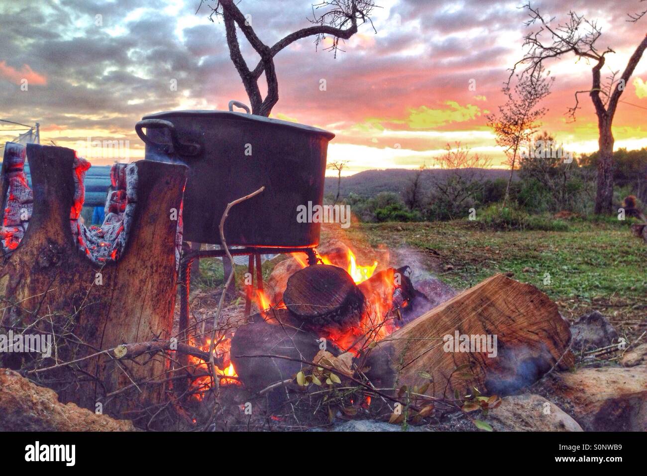 Camp fire at sunset Stock Photo