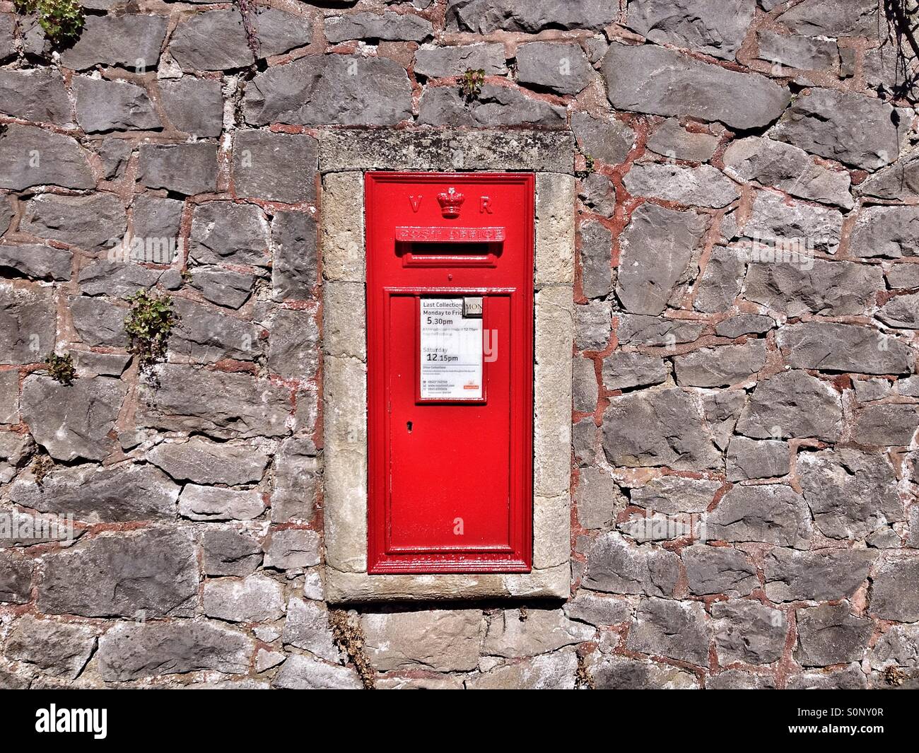 A Victorian post box set in a stone wall on a city street in England - Smartphone Captured Stock Image