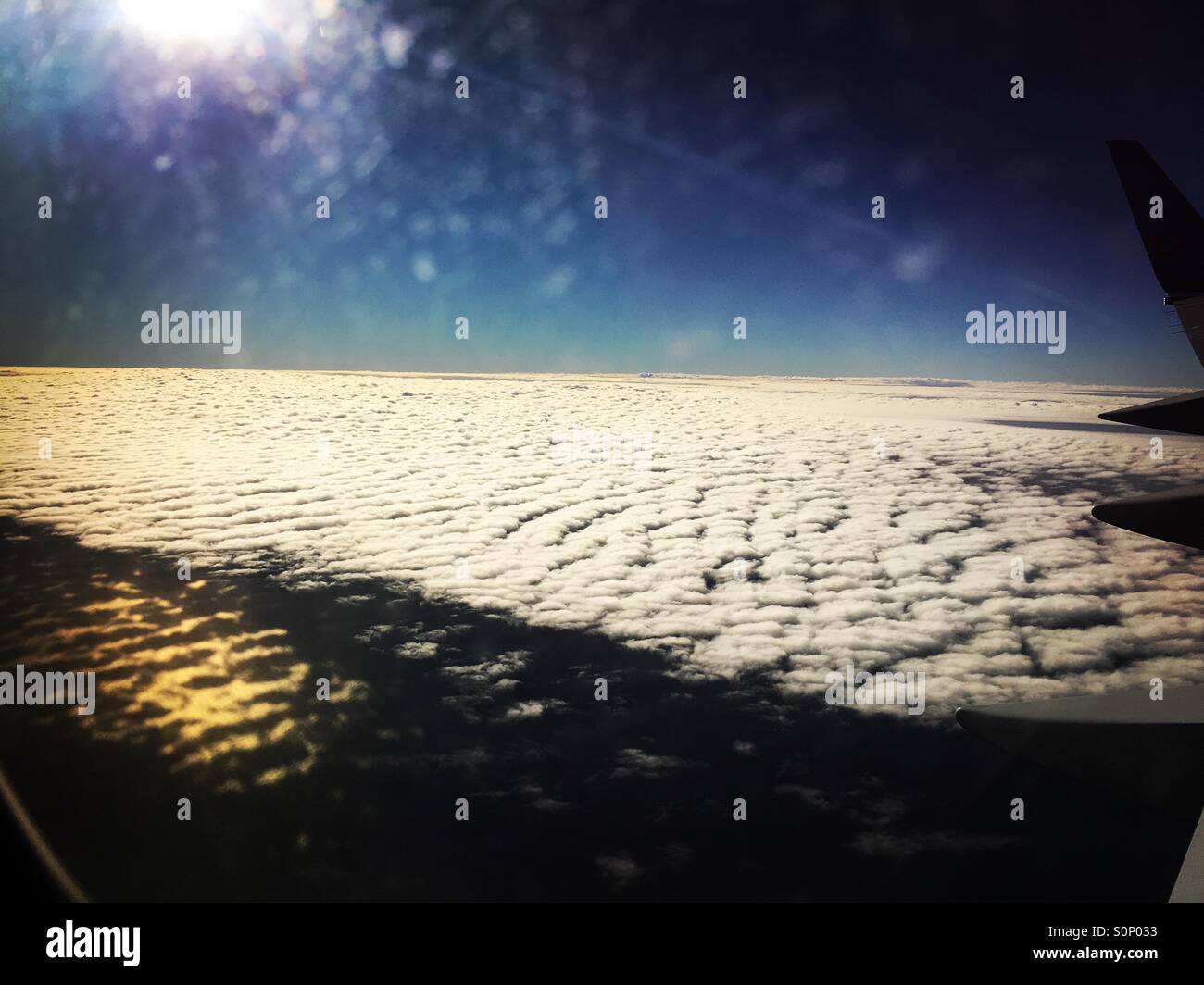 Sunlight and clouds through an airplane window - Smartphone Captured Stock Image