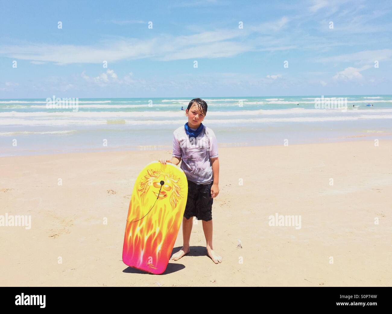 Boy in beach with boogie board. Stock Photo