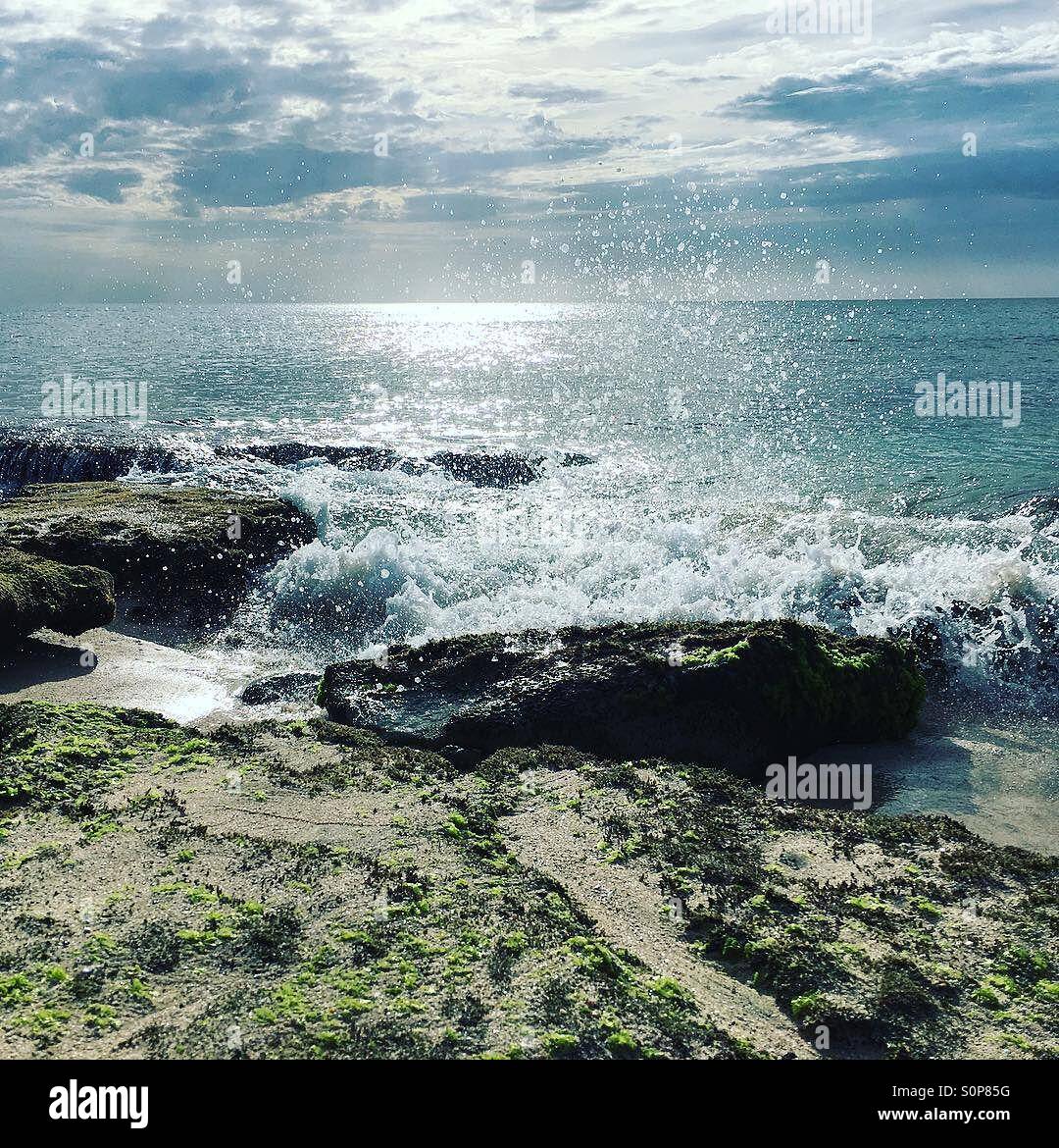 Waves crashing into rocks on tropical beach - Smartphone Captured Stock Image