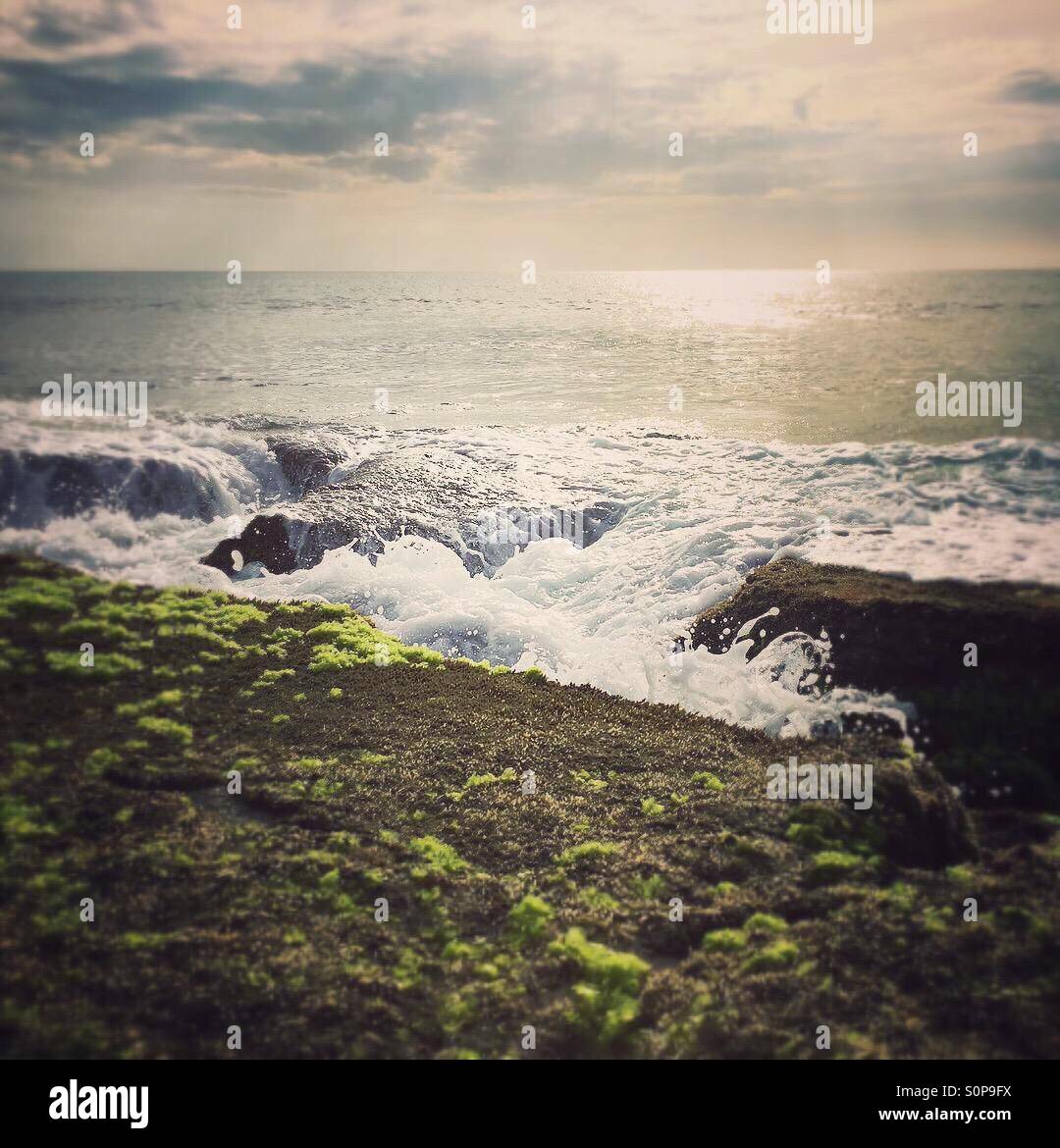 Incoming tide with waves splashing in between rocks - Smartphone Captured Stock Image