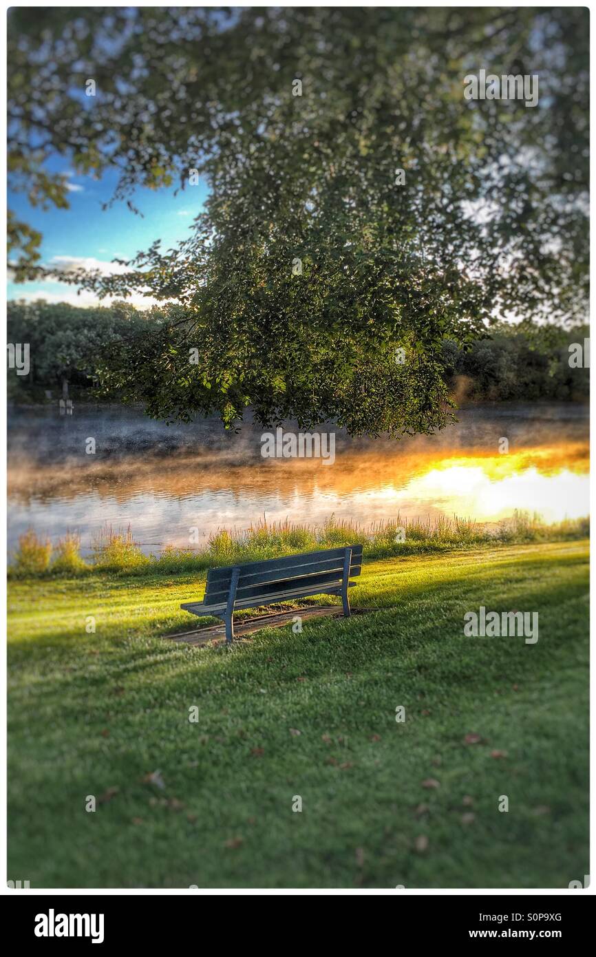 A bench overlooking the Mississippi River at sunrise Stock Photo