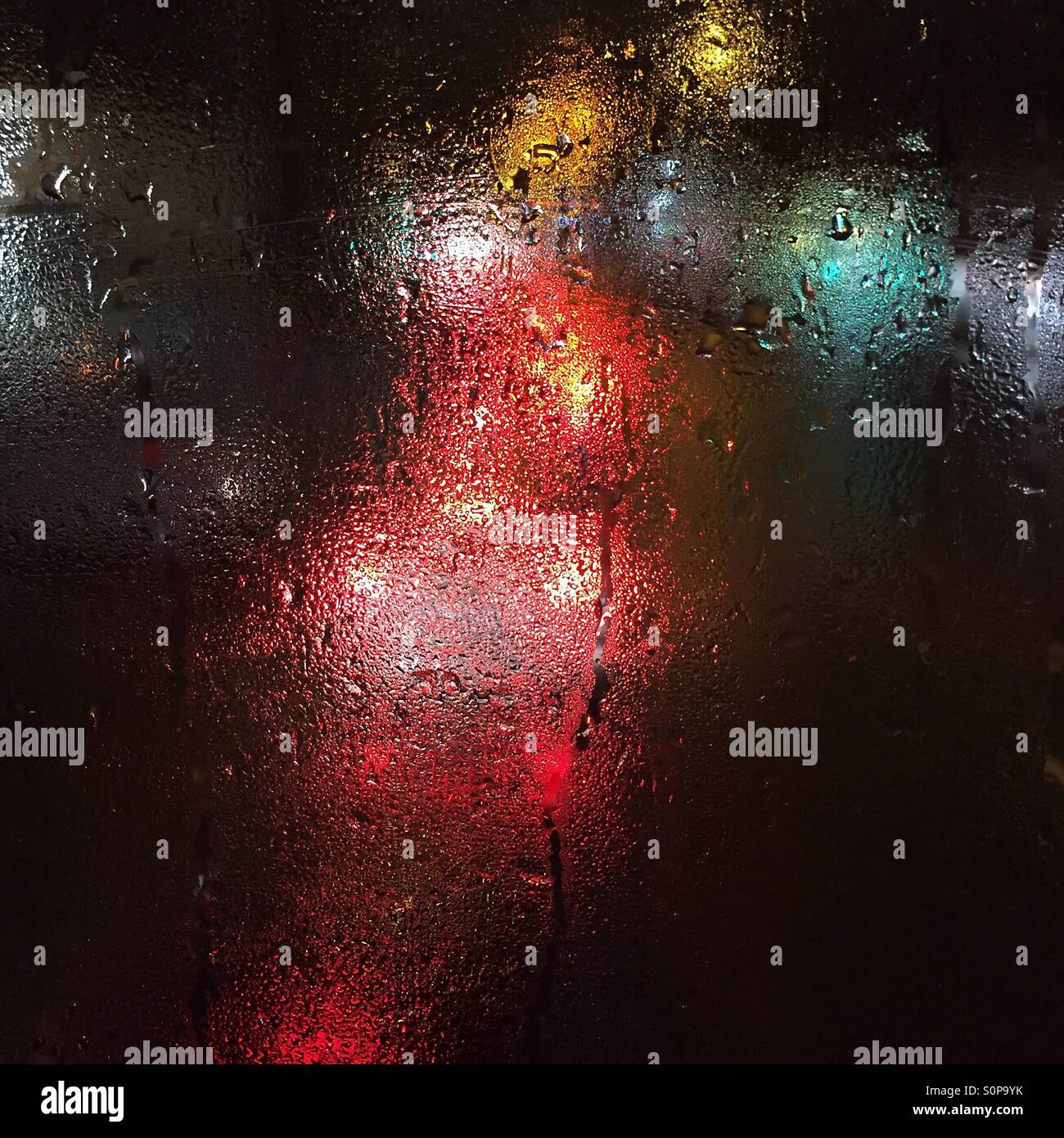 City lights and car lights through a window with condensation taken from a height Stock Photo