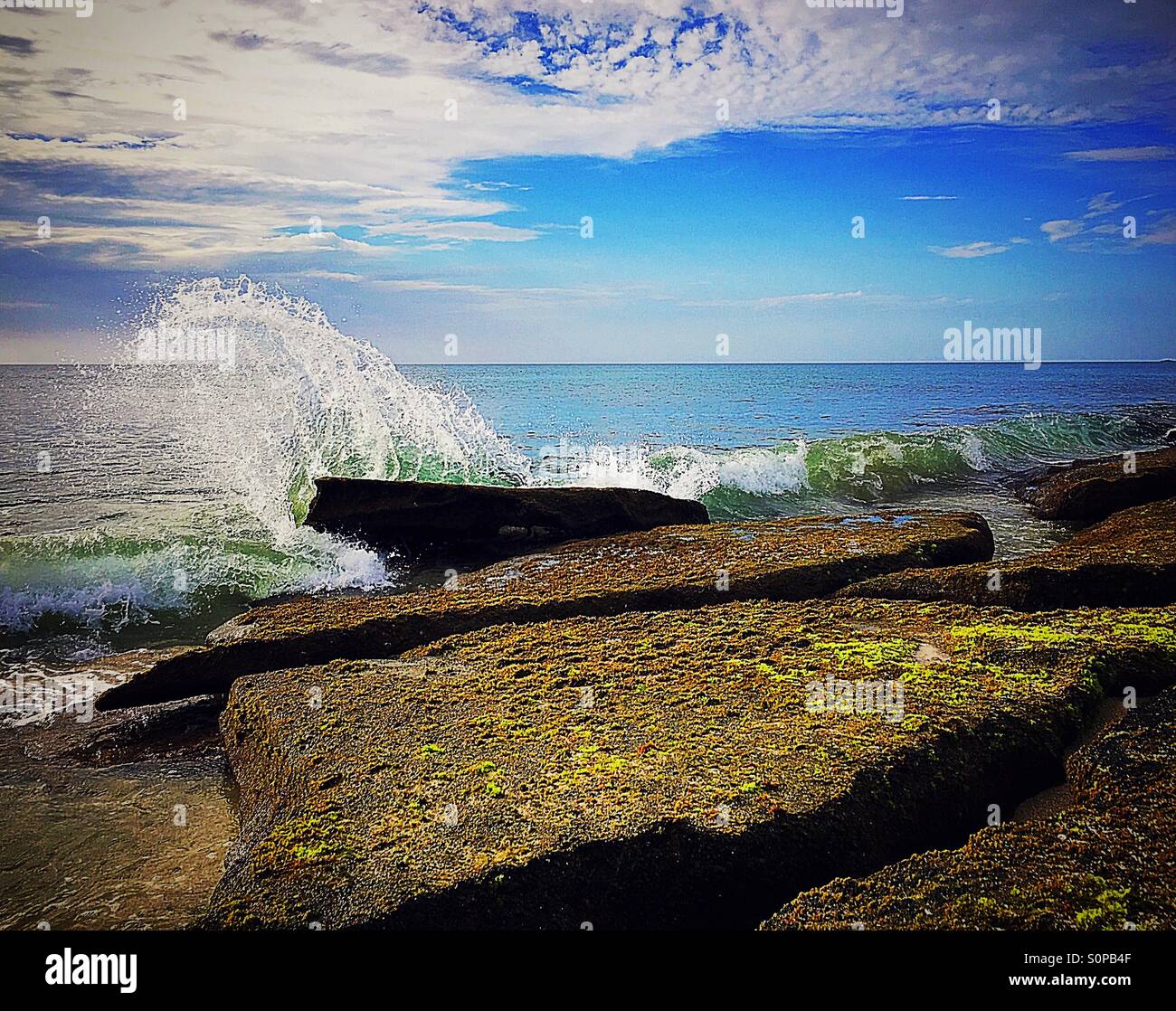 Splash of waves against rocks Stock Photo - Alamy